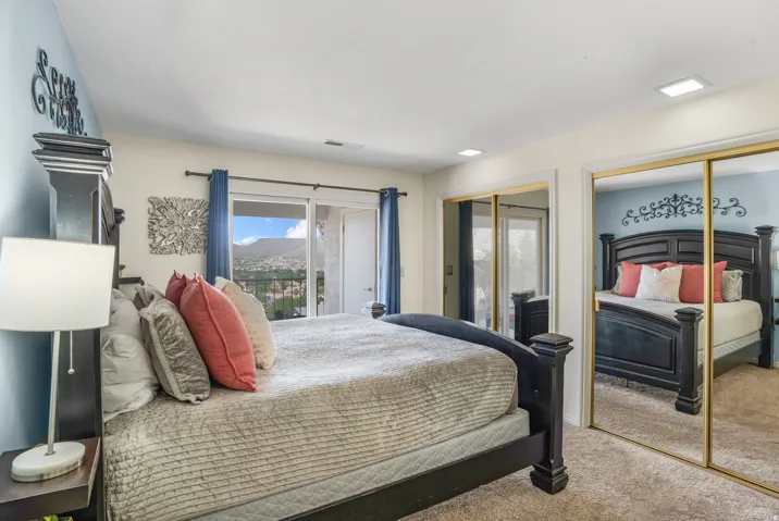 Bedroom featuring sliding glass doors opening to a balcony, mirrored closet doors, carpet flooring, and recessed lighting