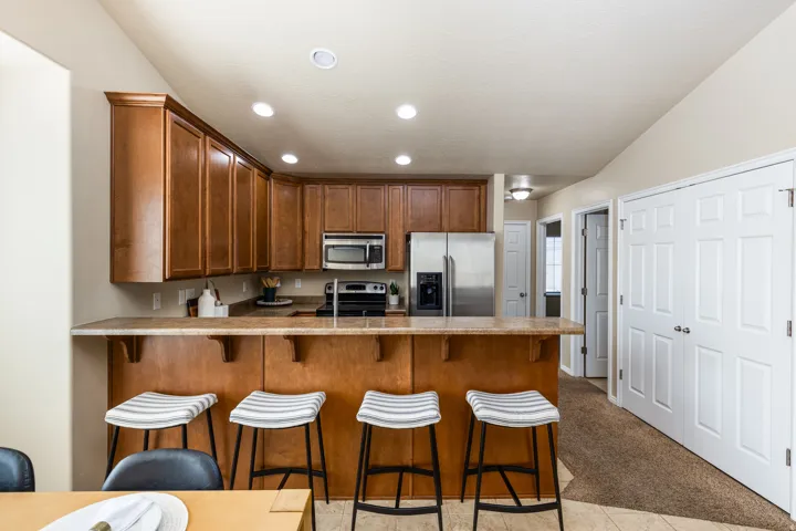 Open-concept kitchen featuring recessed lighting, extensive wood cabinetry, and a peninsula with seating