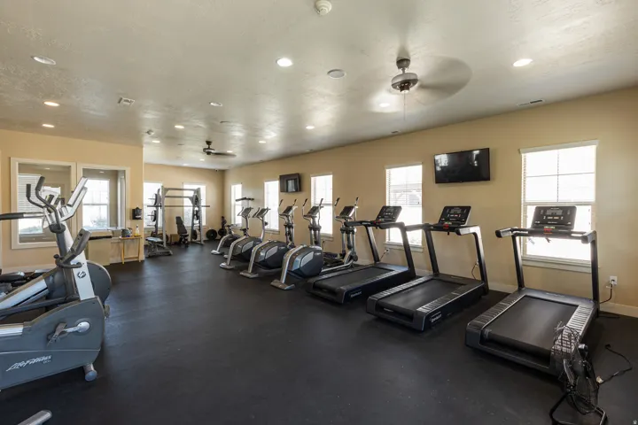 Dedicated fitness space featuring rubberized flooring, multiple windows, recessed lighting, and ceiling fans
