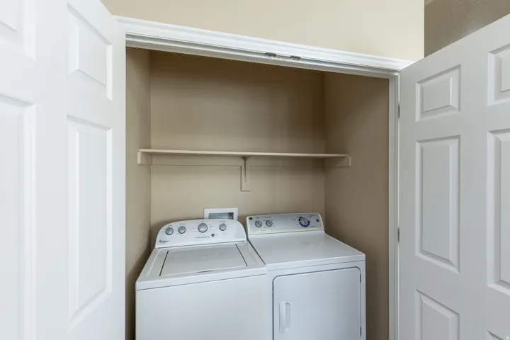Utility closet featuring a built-in shelf, neutral wall color, and crown molding
