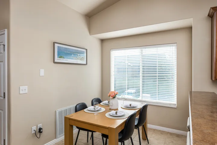 Dining area featuring a window with white blinds, neutral wall paint, and tile flooring