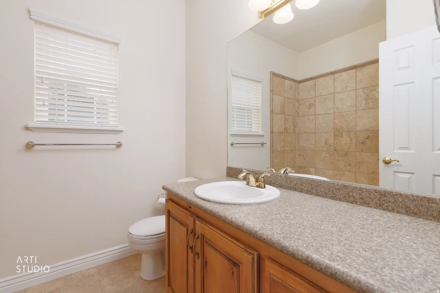 Master Bathroom featuring a light wood vanity with an integrated sink, a speckled countertop, and a large wall-mounted mirror