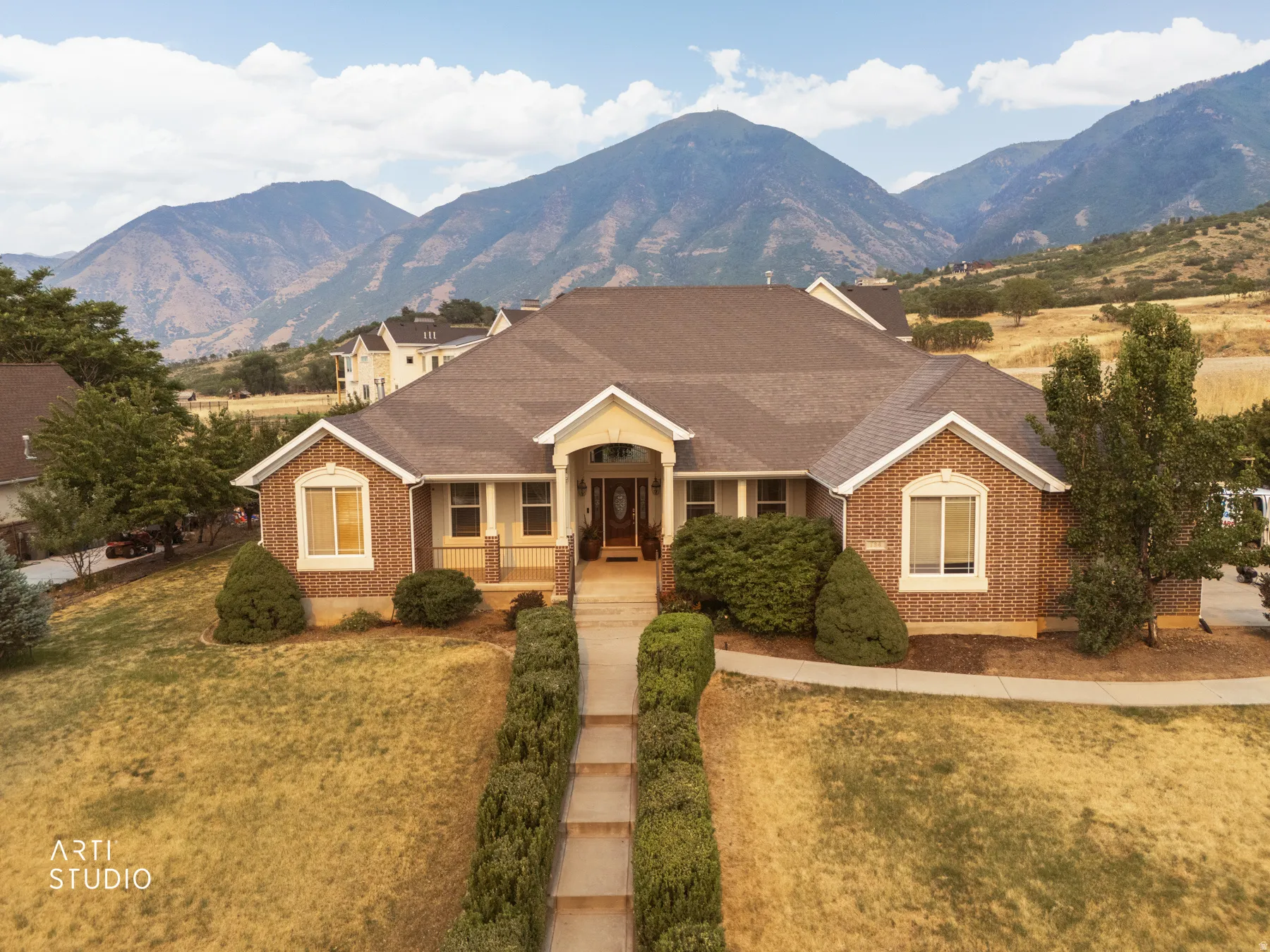 Brick facade residence with a prominent gabled entrance featuring a covered porch