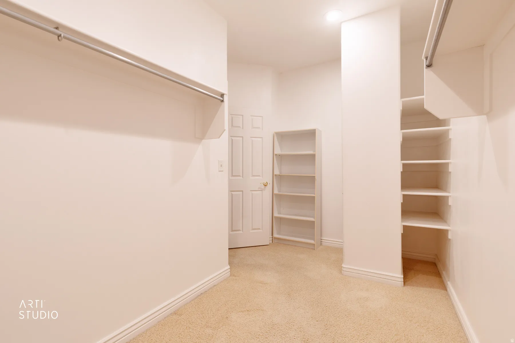 Spacious master closet featuring wall-mounted hanging rods, built-in shelving units, recessed lighting, and neutral carpeting