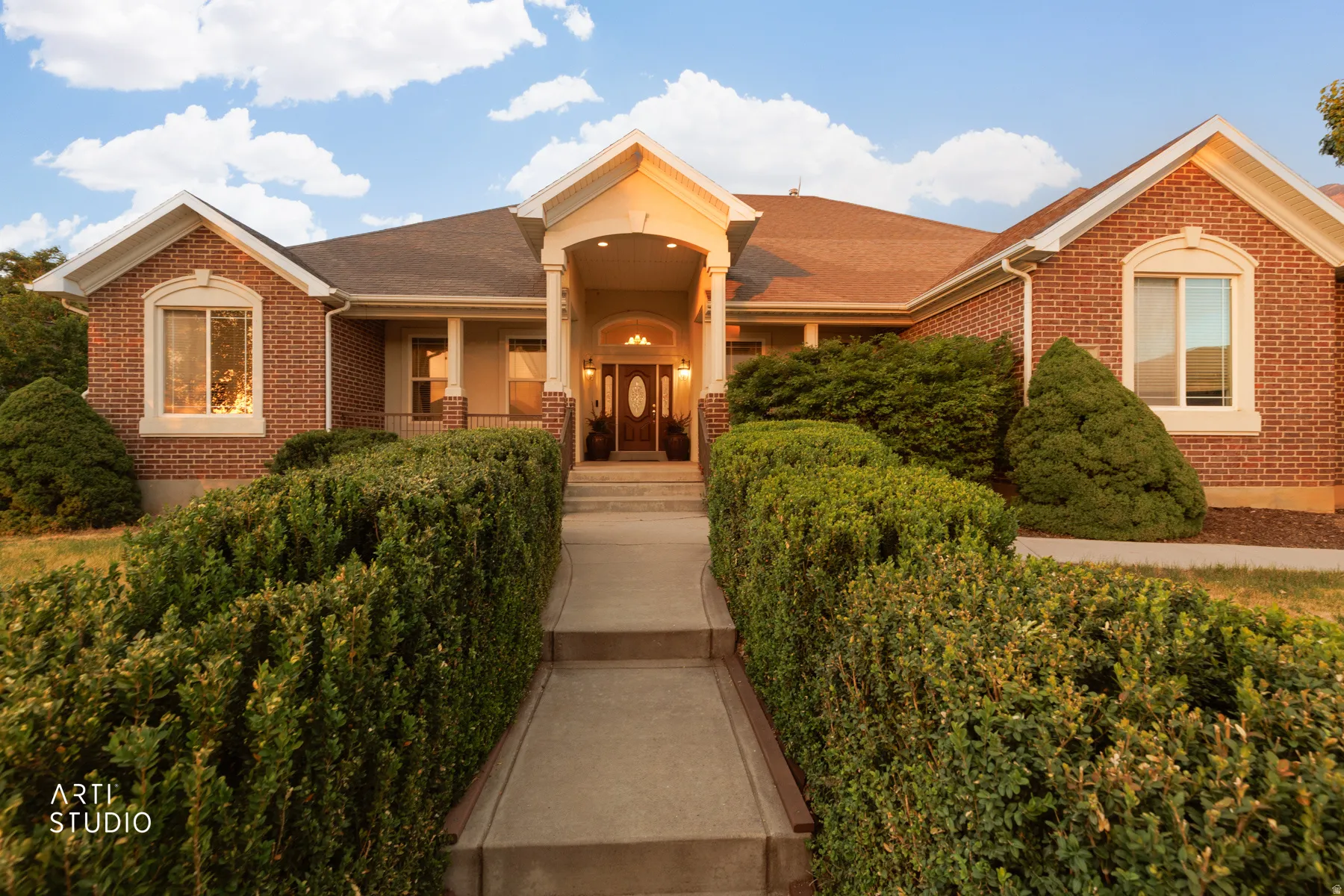 Brick exterior with an arched entry porch, supported by columns