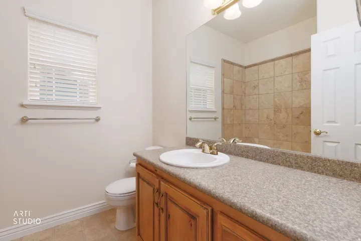 Master Bathroom featuring a light wood vanity with an integrated sink, a speckled countertop, and a large wall-mounted mirror