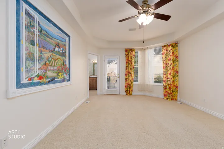 Spacious master bedroom featuring neutral carpet flooring and a neutral painted wall