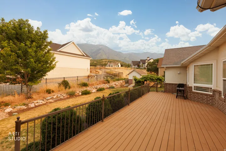 Expansive outdoor deck featuring wood-finish flooring and dark metal railings