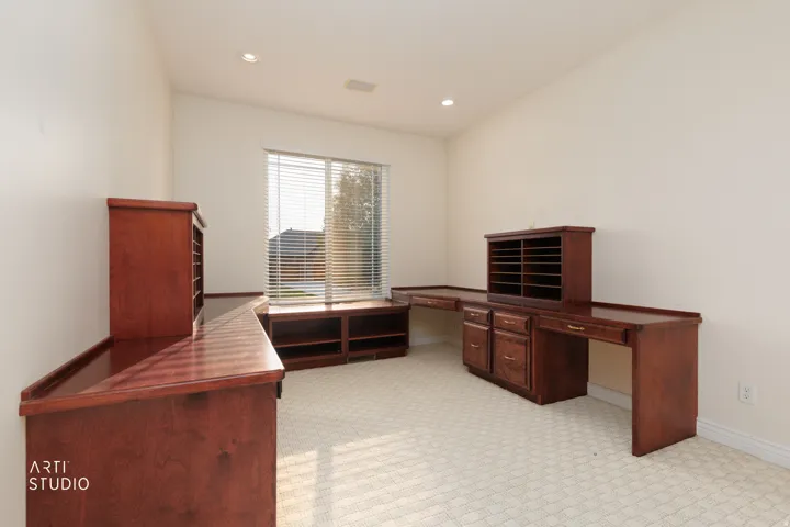 Built-in wood desks and cabinetry with a window bench seating area