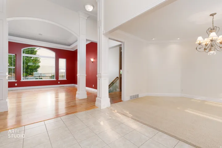 Formal living area featuring a vaulted ceiling and an arched window