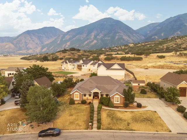 Ranch-style residence featuring a brick facade with stone accents, a landscaped front walkway, and an attached two-car garage