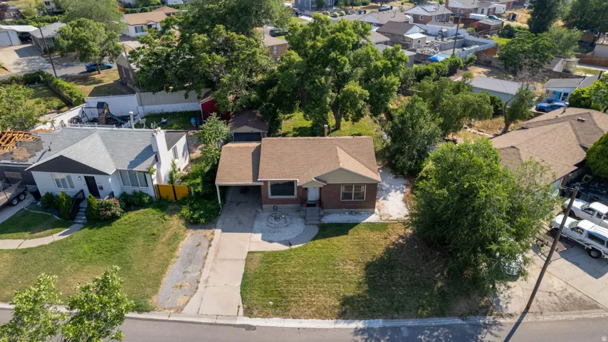 Single-story residence featuring a brown shingle roof, brick facade, and a covered carport