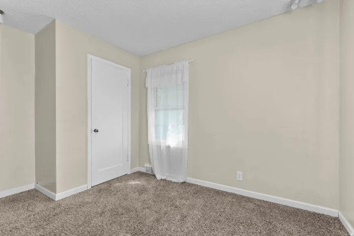 Neutral-toned walls complement the carpeted flooring