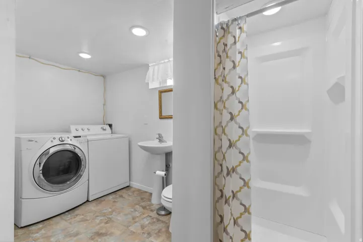 Full bathroom featuring a stand-up shower, pedestal sink, and tiled flooring
