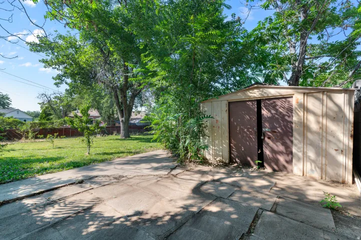 Freestanding metal shed with double doors, set on a concrete slab