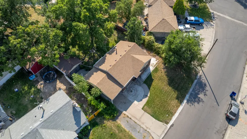 Aerial perspective showcasing a residential property with a brown shingle roof and an attached garage