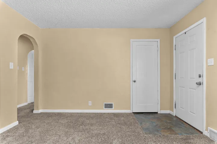 Carpeted interior space with beige walls and white trim