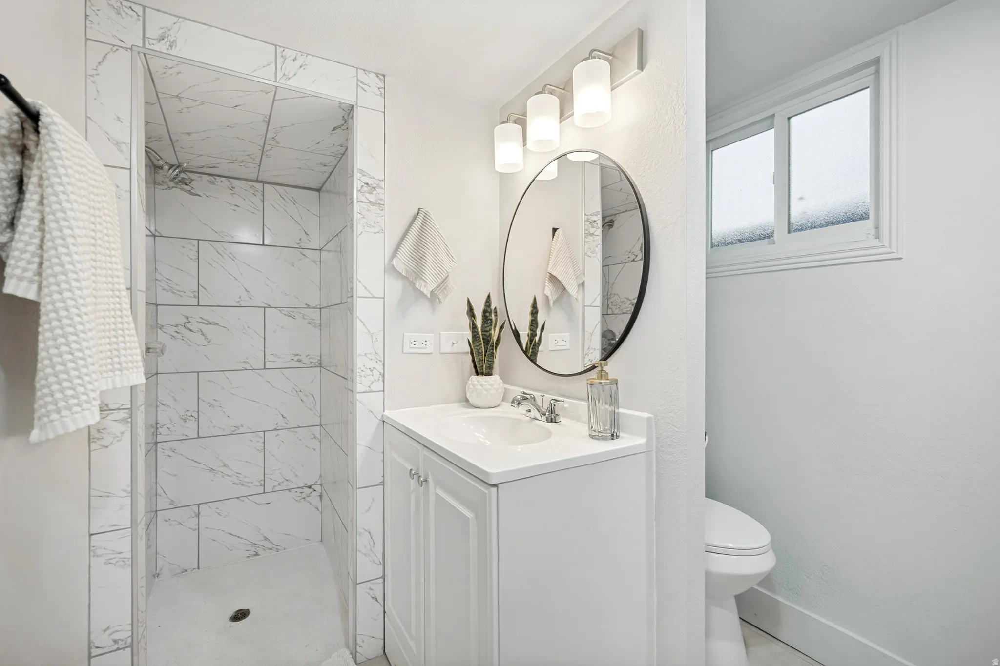 Walk-in shower with large format tile surround and integrated niche
