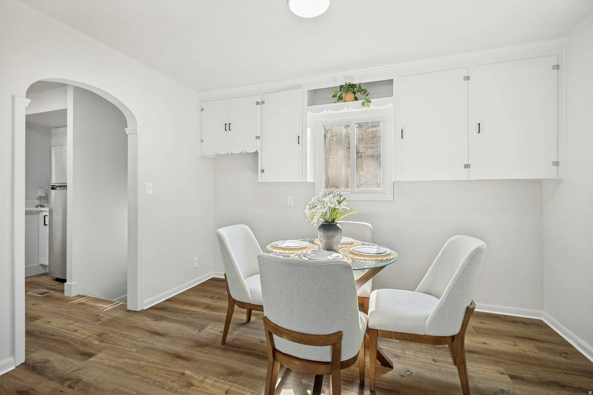 Dining area featuring wood-finish flooring and an arched doorway
