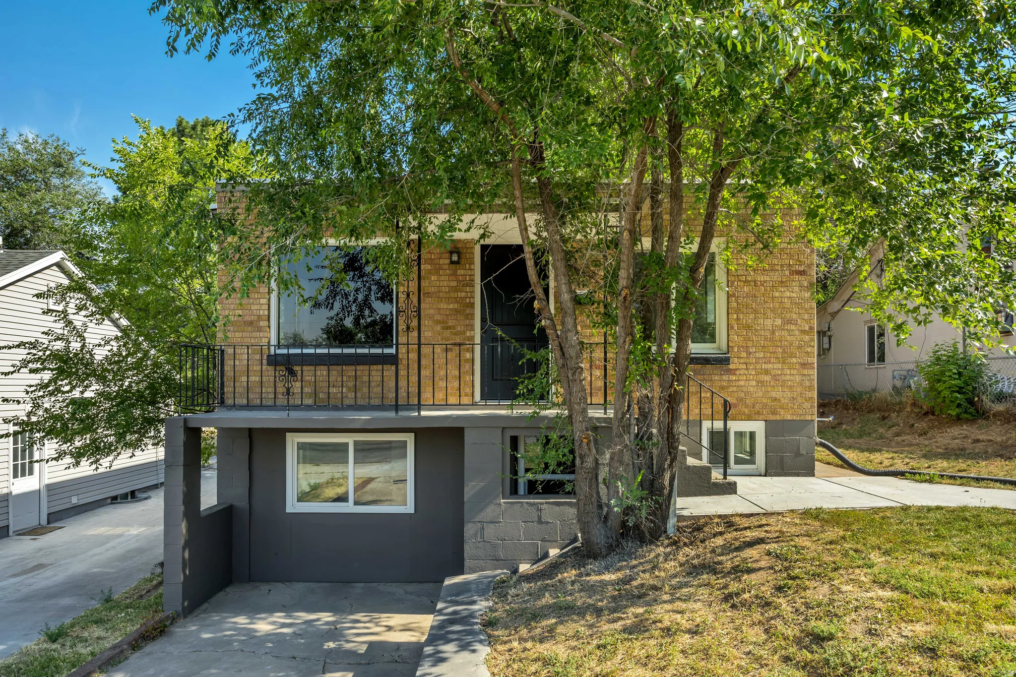 Brick exterior with a second-story balcony featuring black iron railings