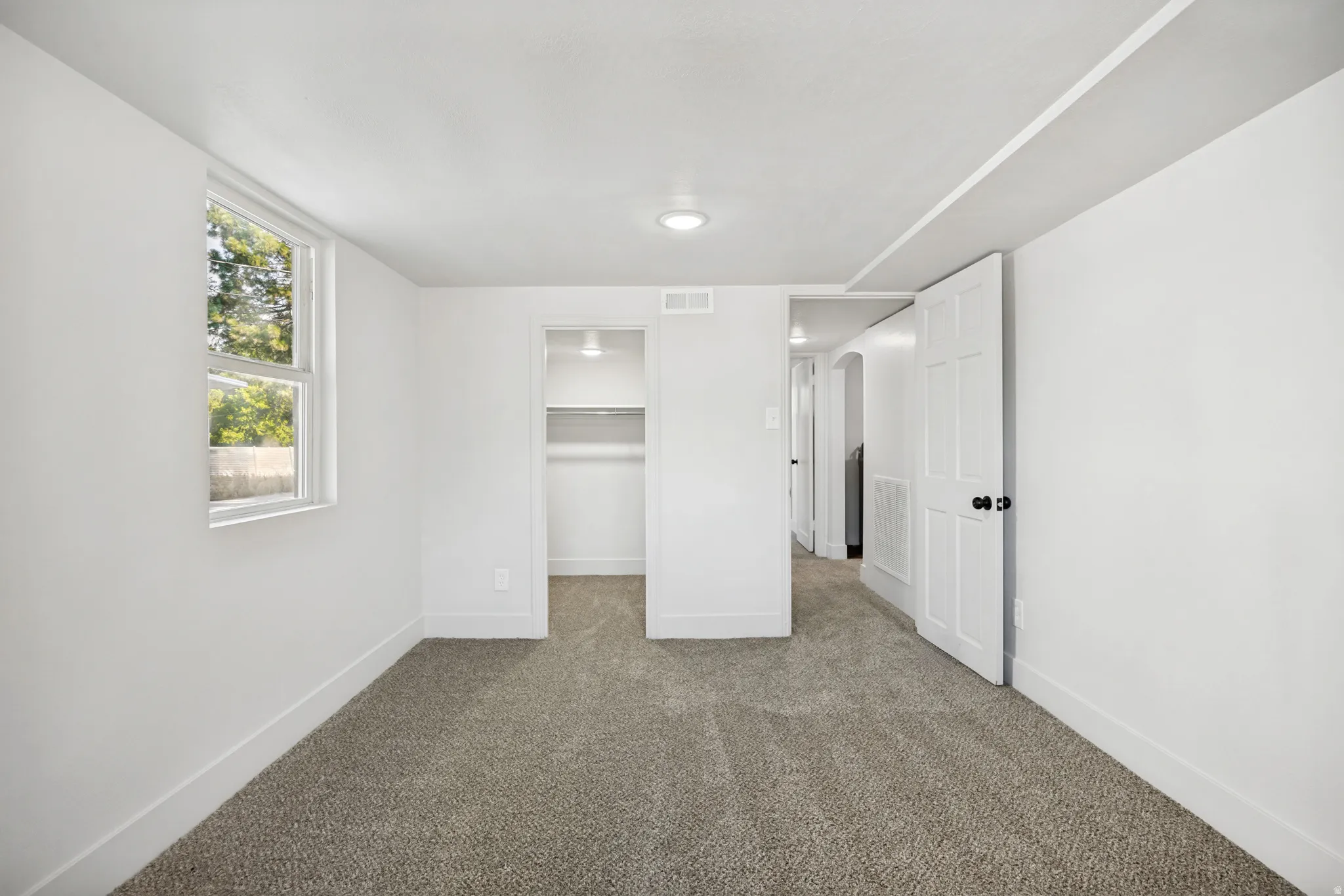 Carpeted room featuring a double-hung window, recessed lighting, and a built-in closet with shelving