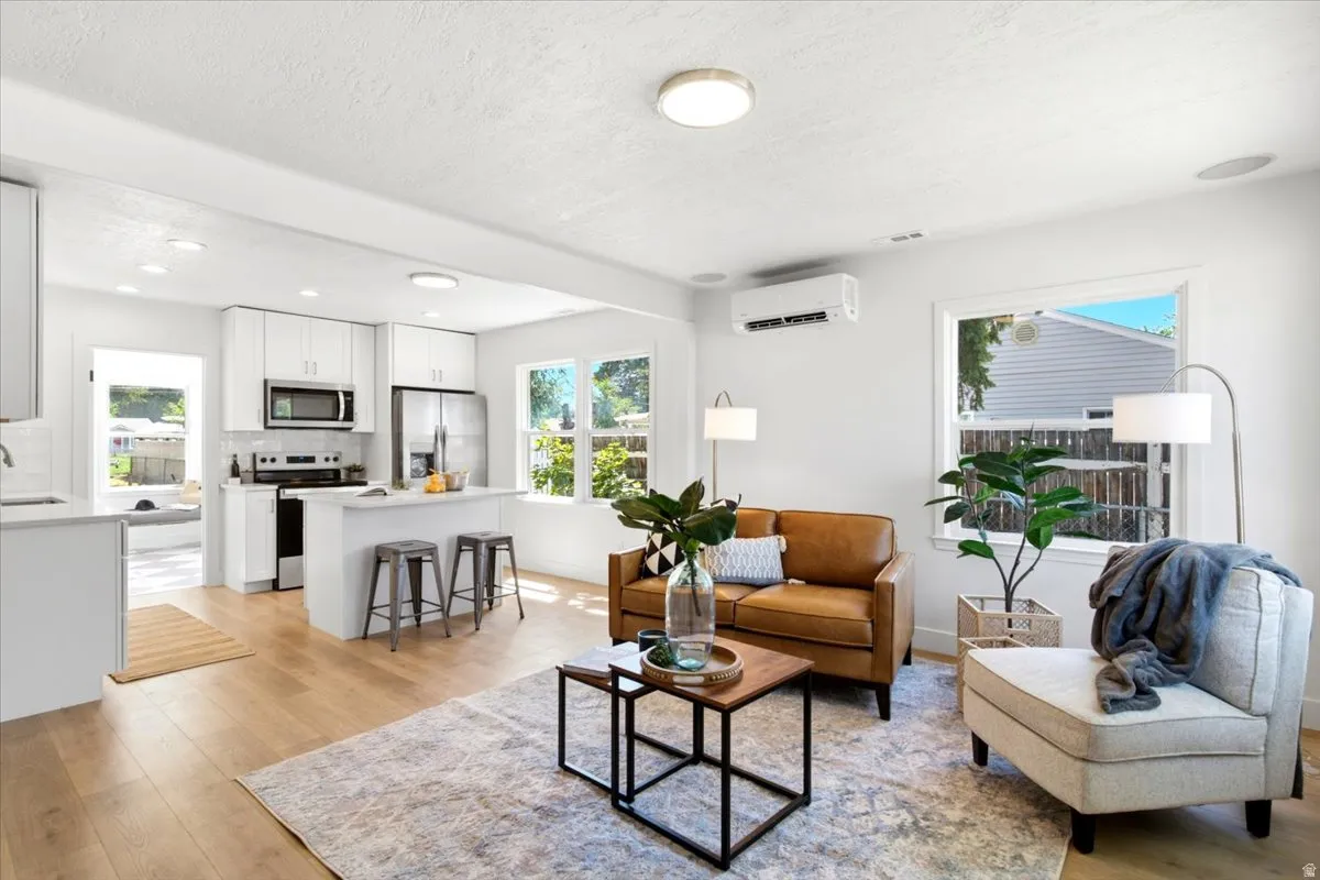 Open-concept living space featuring wood-finish flooring, white walls, and recessed lighting