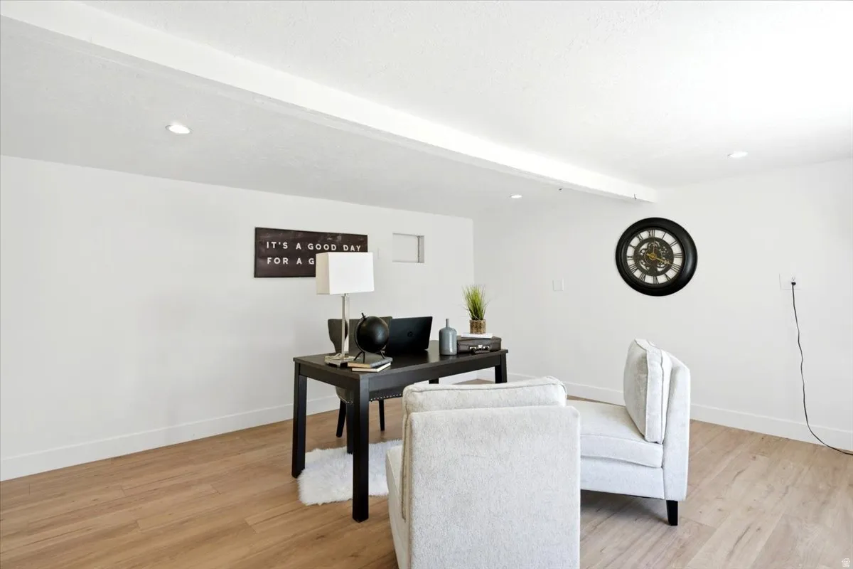 Light wood-finish flooring extending throughout, complemented by white walls and recessed ceiling lighting