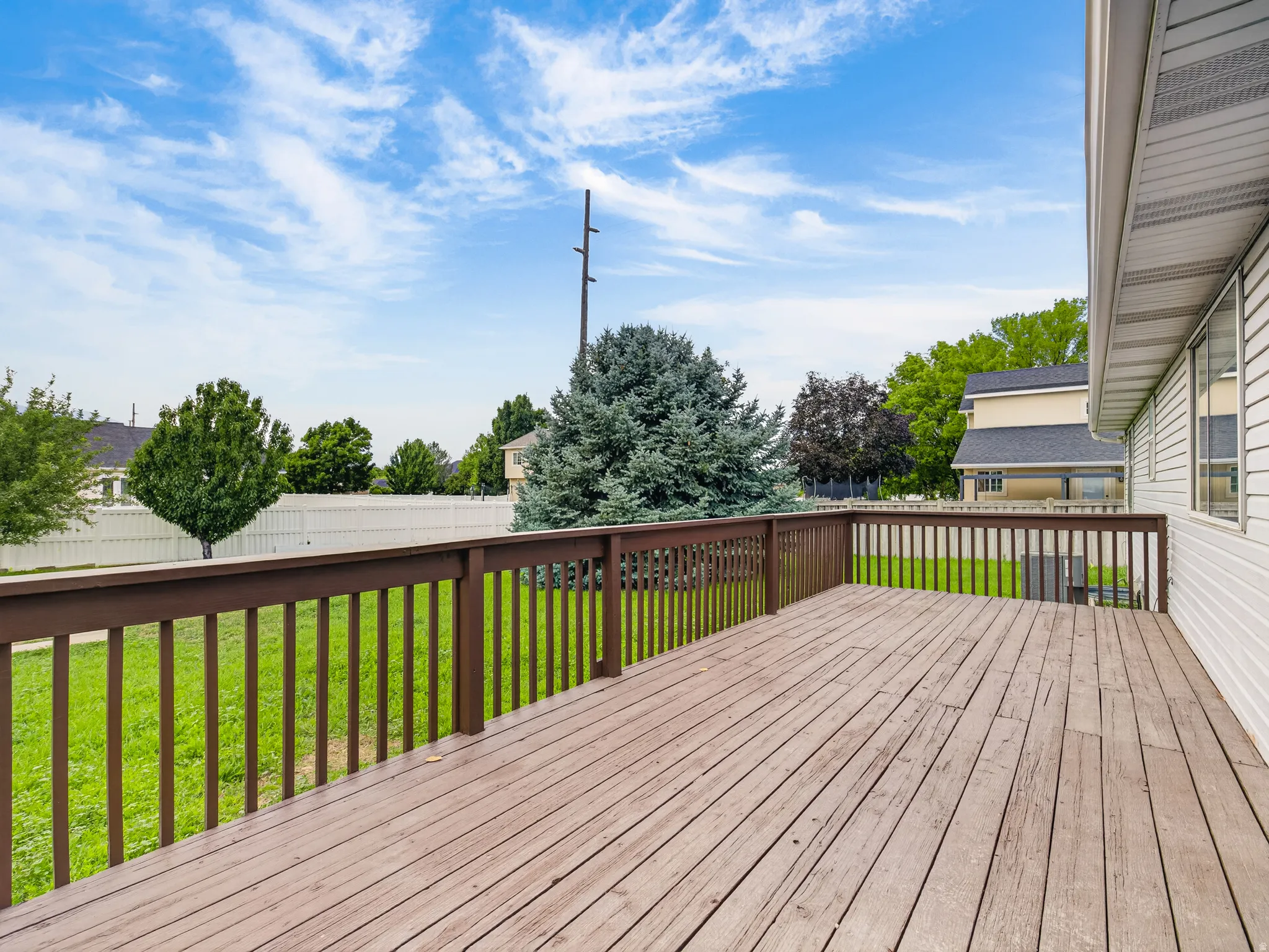 Spacious outdoor deck with wood-finish flooring and a full-height railing