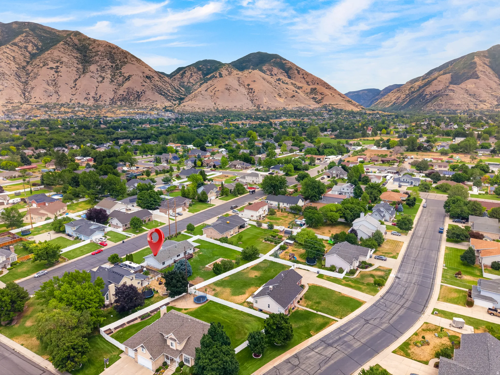 Aerial perspective showcasing a residential neighborhood with prominent mountain backdrop