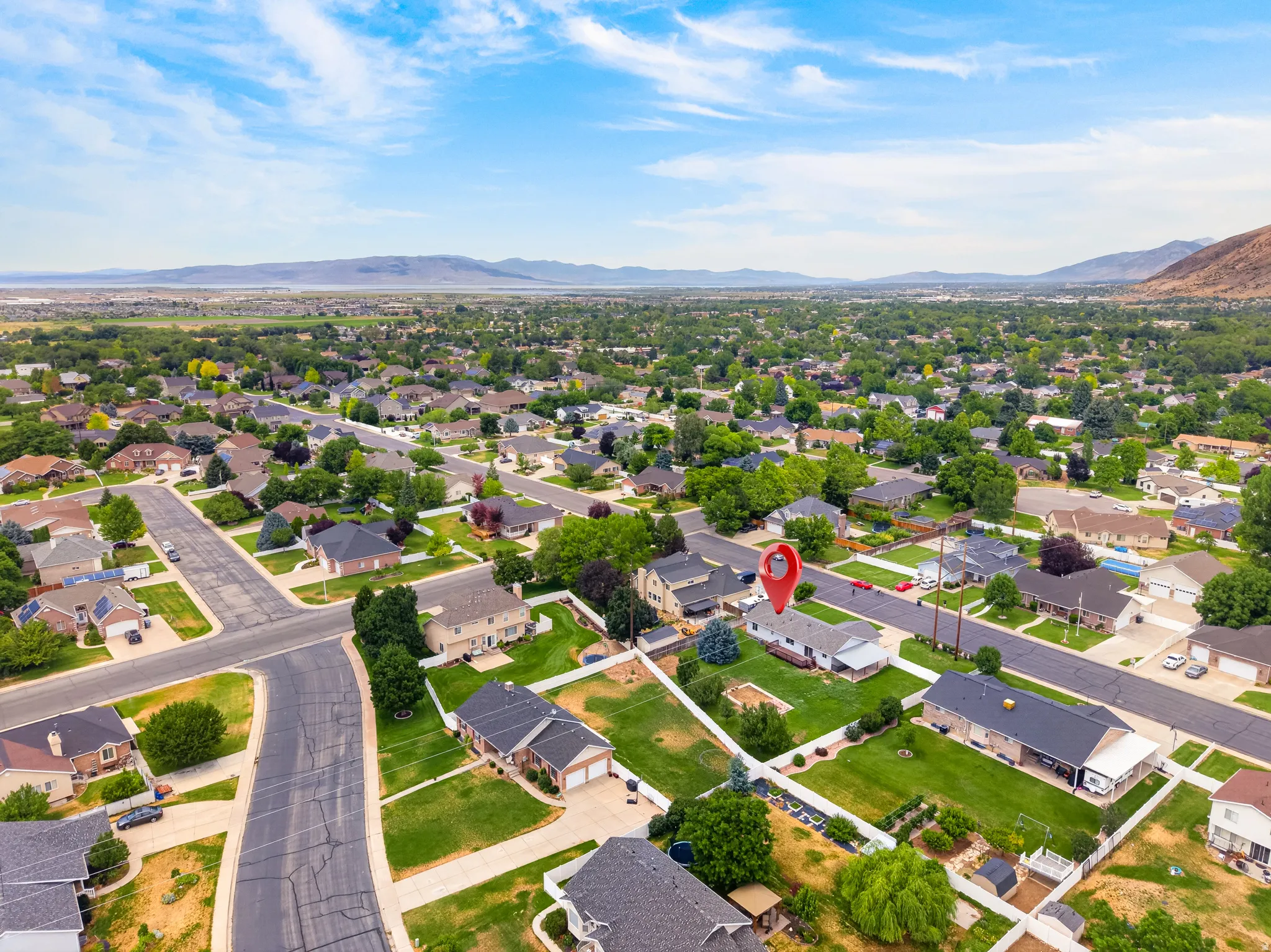Residential neighborhood featuring mature trees and mountain scenery