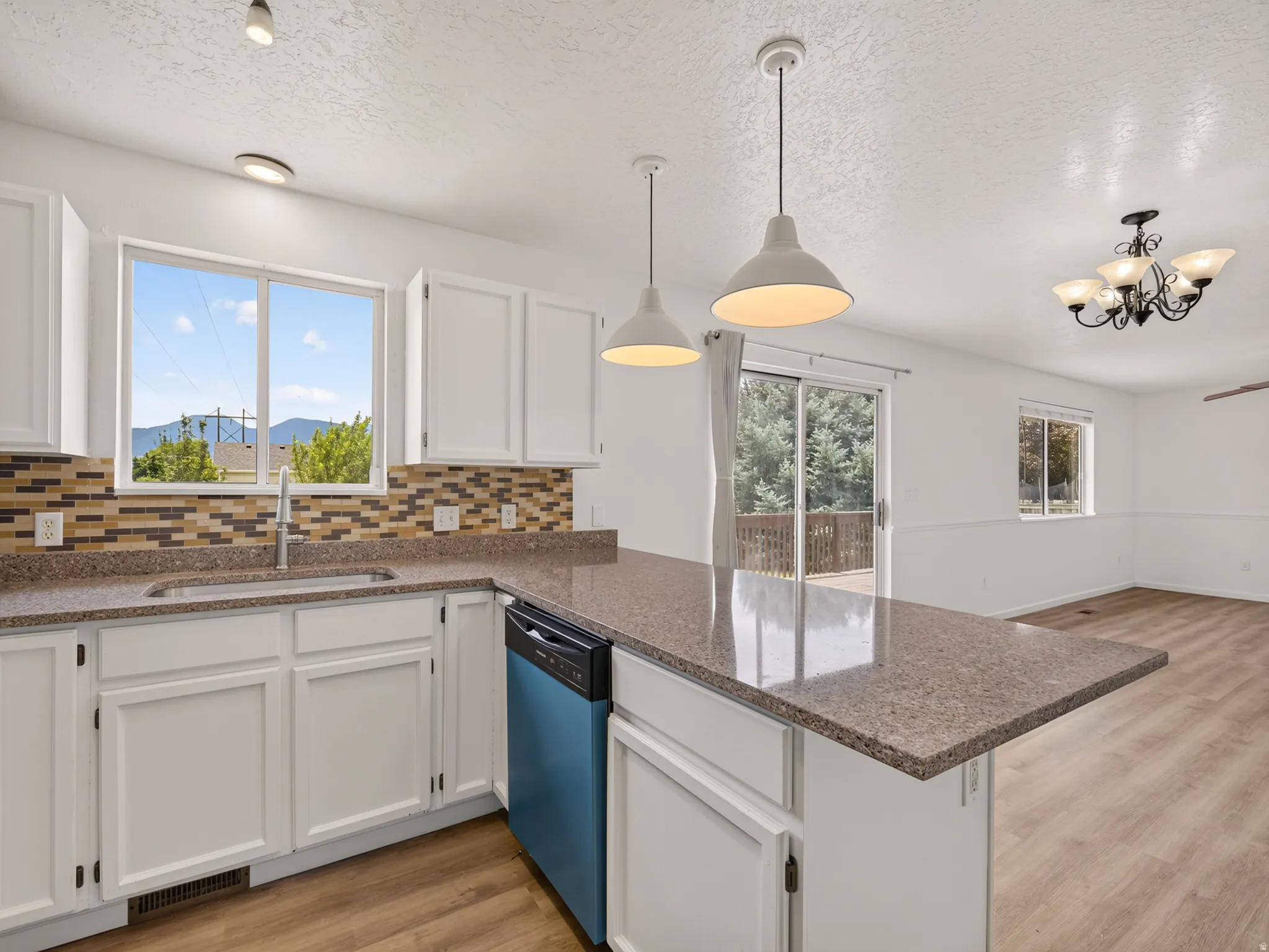 Kitchen featuring white cabinetry, stone-finish countertops, and a tiled backsplash