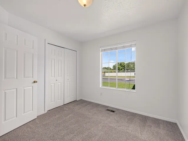 Broad window with blinds, white trim, and a clear exterior view