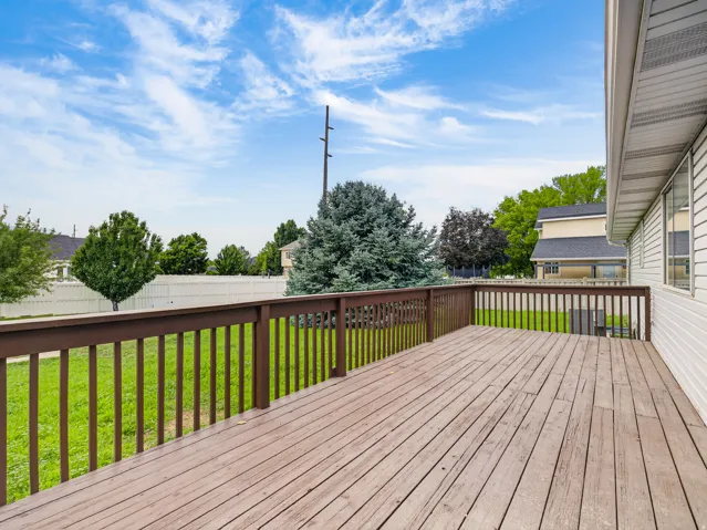 Spacious outdoor deck with wood-finish flooring and a full-height railing