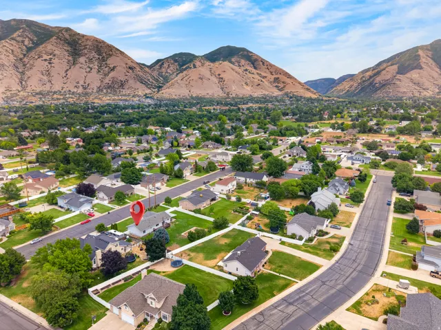 Aerial perspective showcasing a residential neighborhood with prominent mountain backdrop