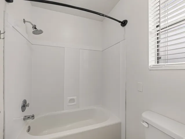 White tub and shower combination with chrome fixtures
