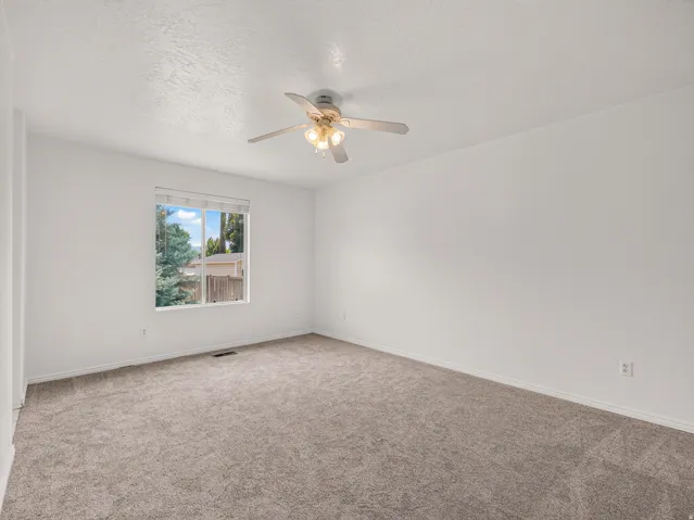 Spacious room featuring neutral carpeting and white walls