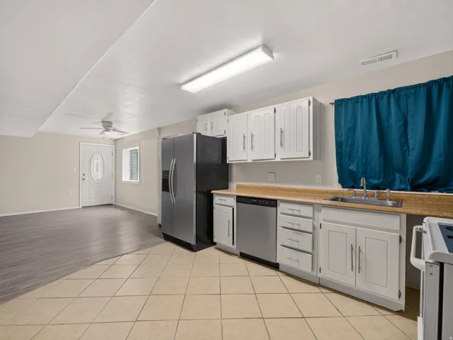 Kitchen featuring white cabinetry, stainless steel appliances, and a tiled floor