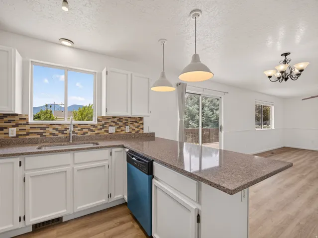 Kitchen featuring white cabinetry, stone-finish countertops, and a tiled backsplash