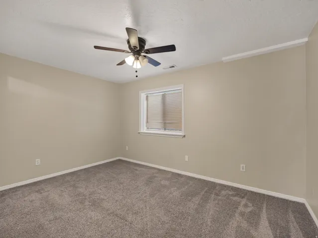 Neutral-toned walls complement plush grey carpeting