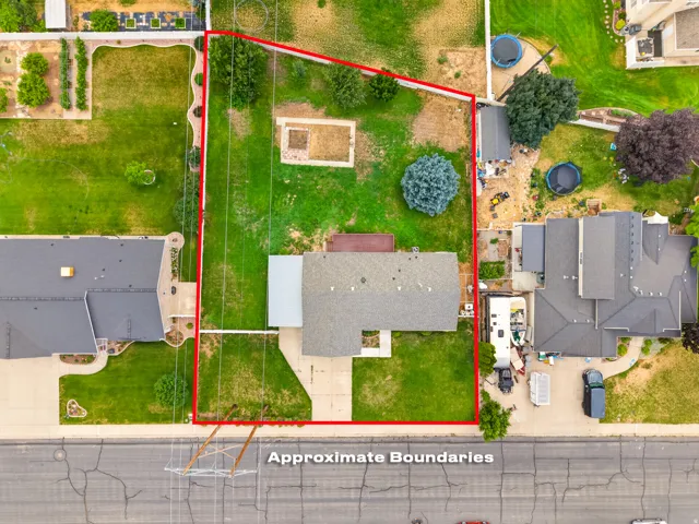 Expansive property featuring a large grass lawn, mature trees, and an extended driveway
