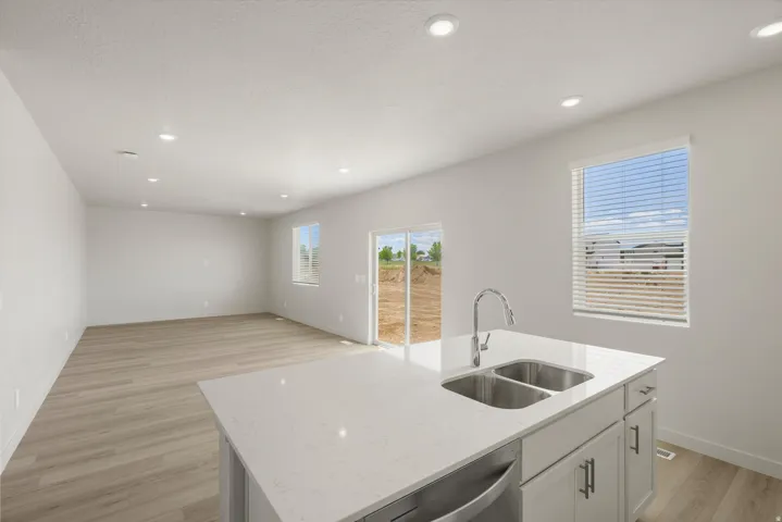 Kitchen island with a double basin stainless steel sink, gooseneck faucet, and light-colored countertop