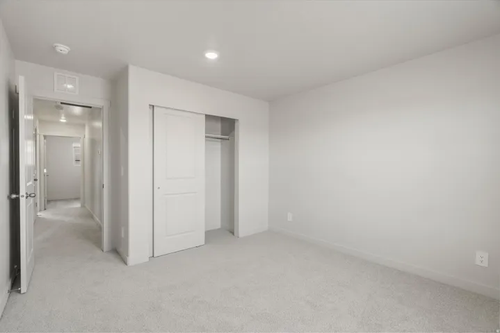 Bedroom featuring light gray carpeting, recessed lighting, and white baseboards