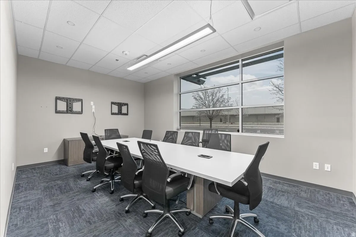 Conference room featuring a large window, drop-tile ceiling, recessed lighting, and patterned carpet flooring