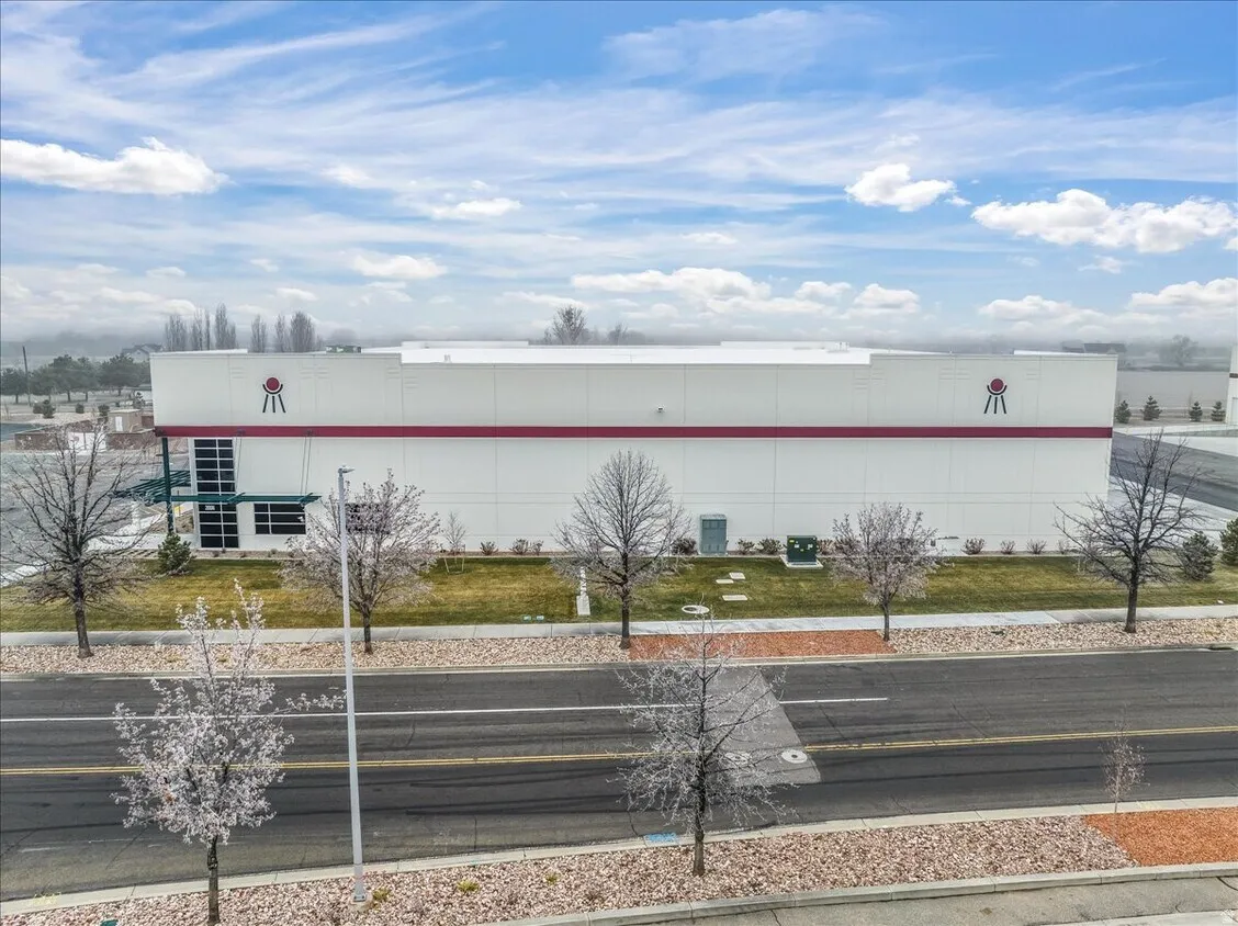 Modern commercial building with a white facade and red band detailing