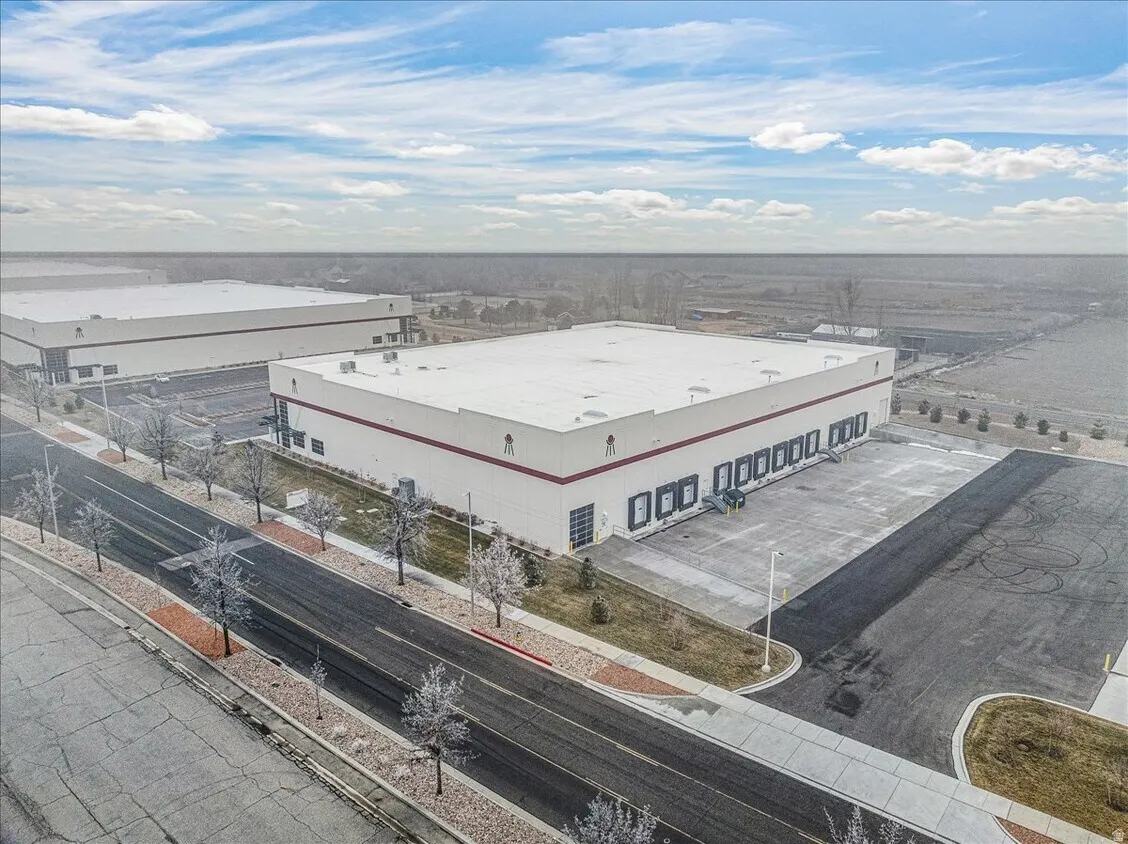 Modern warehouse facility featuring an expansive white exterior with red trim