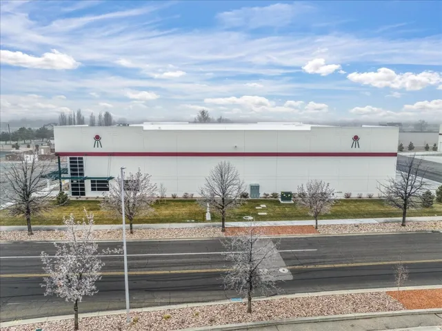 Modern commercial building with a white facade and red band detailing