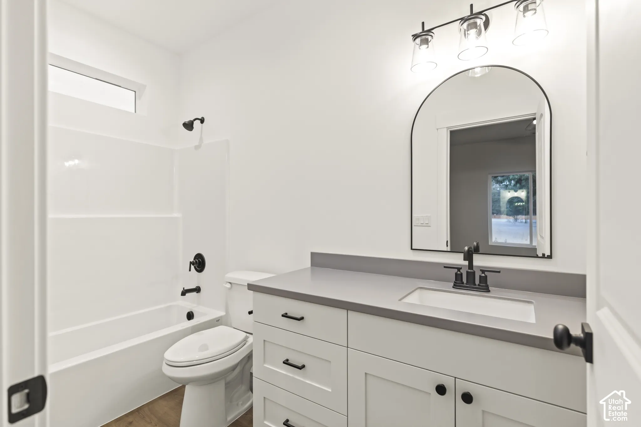 Contemporary bathroom featuring a white vanity with shaker-style cabinetry, a light gray countertop, and an undermount sink