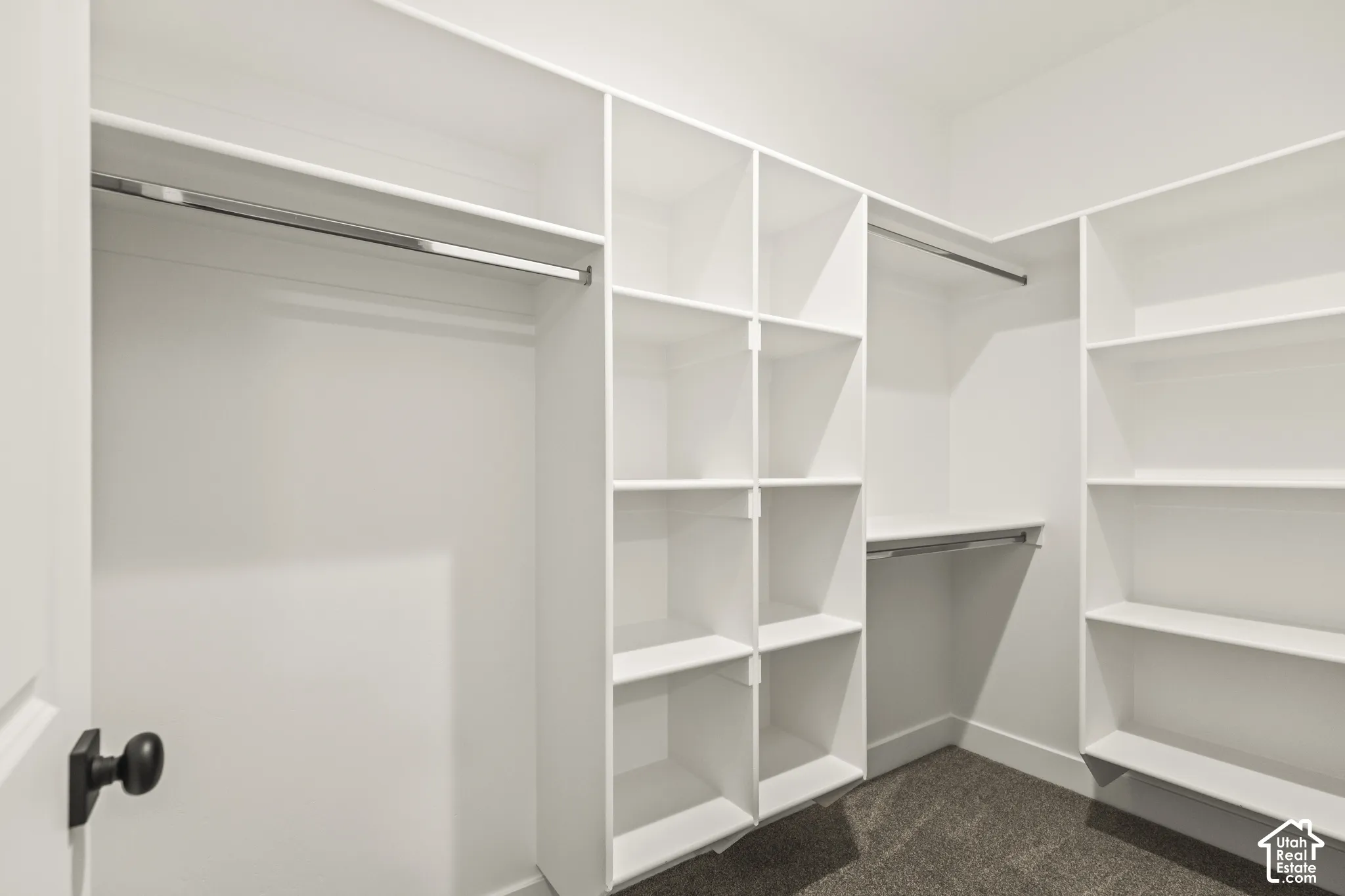 Custom-designed closet system featuring white shelving and hanging rods