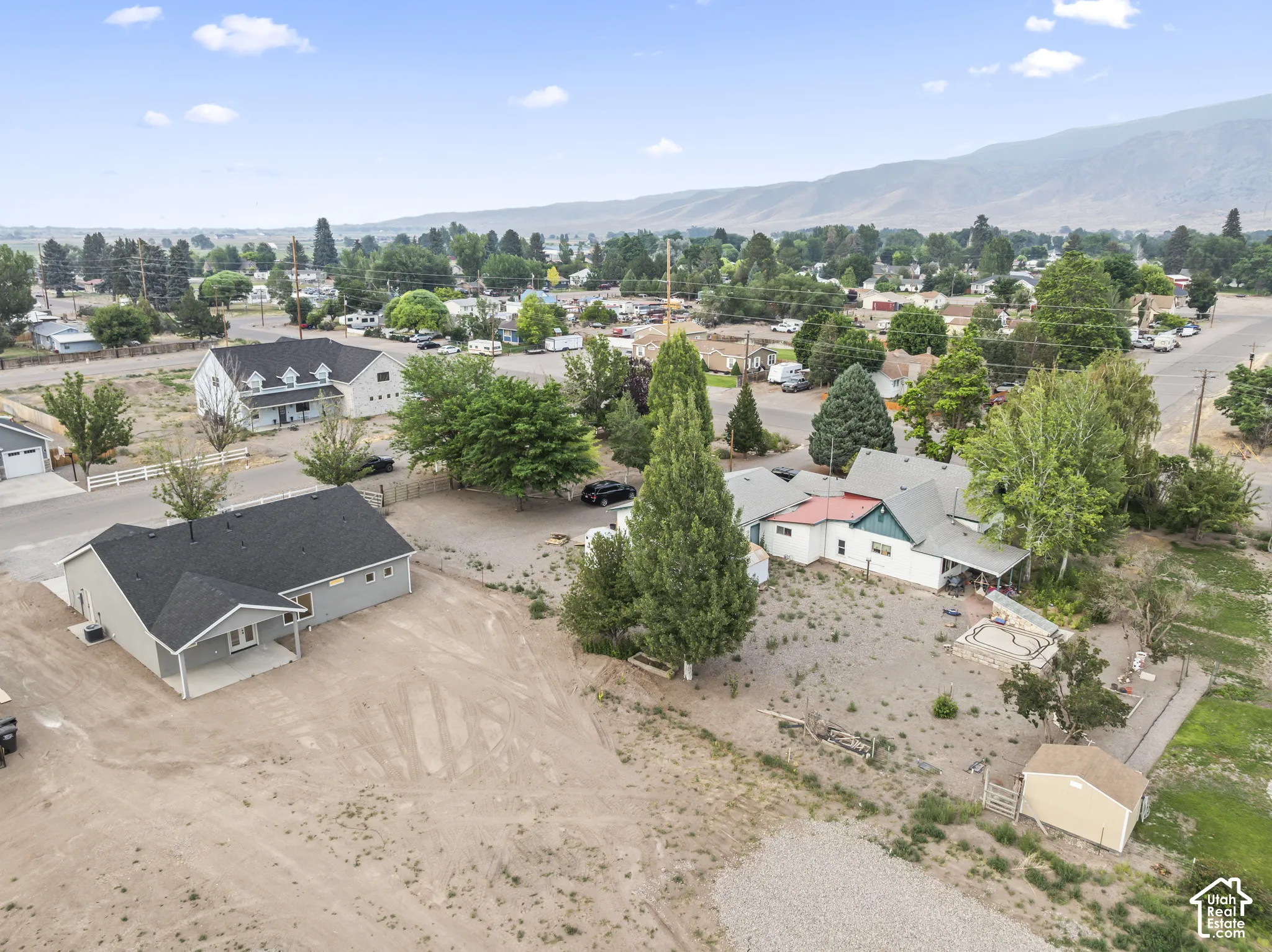 Expansive property featuring a newly constructed single-story residence with a covered porch and dark shingle roof