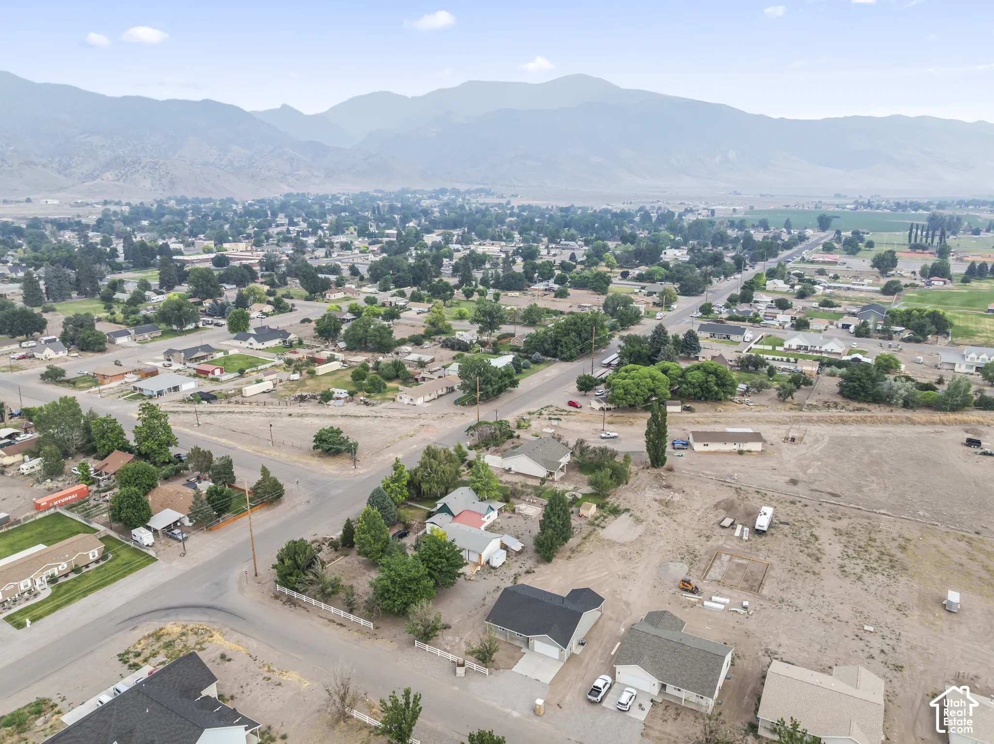 Expansive lot featuring a clear, level building area with surrounding residential properties and mature trees